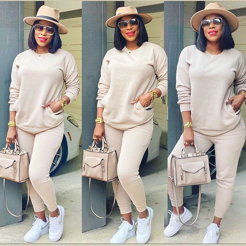 Beige two piece-set. long sleeve sweater top and long cozy lounge wear pants to match paired with dark glasses, white sneakers, cream hand purse